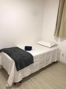 a white bed with a black blanket on top of it at AP ALPHA 5 STAr in Vespasiano