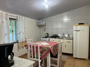 a small kitchen with a table and a refrigerator at CASA SUZENA - Penha SC a 300 metros do Beto Carrero e Praias in Penha