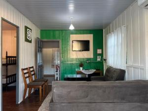 a living room with a couch and a green wall at CASA SUZENA - Penha SC a 300 metros do Beto Carrero e Praias in Penha
