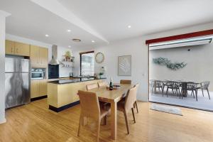 a kitchen and dining room with a table and chairs at Penthouse at Colonial in Noosaville +12 photos