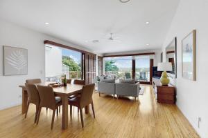 a dining room and living room with a table and chairs at Penthouse at Colonial in Noosaville