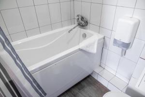 a white bath tub in a bathroom with a toilet at RA na Rybinskoy 7 in Saint Petersburg