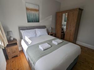 LongbentonにあるBeautiful Benton Baseの大きなベッドとタオル2枚のある寝室 +2枚の写真