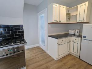 LongbentonにあるBeautiful Benton Baseの白いキャビネットとコンロ付きオーブンを備えたキッチン