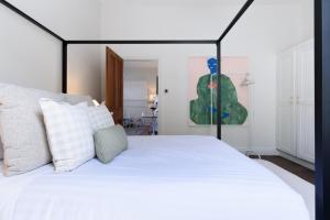 a bedroom with a white bed with a black frame at Elegant 2-Bedroom Home with Curated Decor & Outdoor Entertaining in Inveresk
