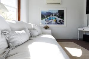 a white couch in a living room with a pool at Elegant 2-Bedroom Home with Curated Decor & Outdoor Entertaining in Inveresk