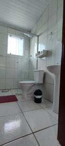 a bathroom with a toilet and a sink at Descanse na Praia de Fora in Palhoça +25 photos