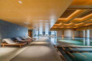 ShuyangShuyang Honor International Hotel的带躺椅的游泳池和游泳池