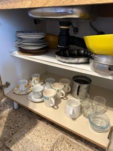 a shelf filled with cups and plates and dishes at La Clementina in San Clemente del Tuyú