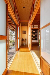 un pasillo de una casa con suelo y ventanas de madera en 潮宿enjoykeys A private rental space with a Japanese garden, en Higashiōsaka