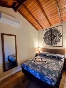 a bedroom with a bed and a mirror at Casa das Dunas in Garopaba