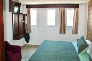 a bedroom with a bed and two windows at Hotel Estrella Apt B in Zacatlán