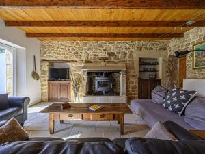 Una sala de estar con un sofá y una chimenea. en Étel - Longère 7 pièces 150 m² - Wifi - Jardin clos - FR-1-479-225, en Étel