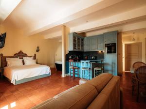 a bedroom with a bed and a kitchen with a couch at Appartement de charme climatisé, centre historique de Pézenas - FR-1-607-214 in Pézenas