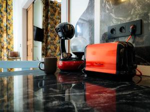 an orange suitcase sitting on a table next to a coffee maker at Appartement de charme, climatisé, animaux admis, centre historique de Pézenas - FR-1-607-215 in Pézenas +7 photos