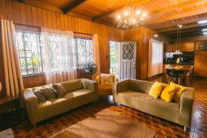 a living room with two couches and a table at Baguio City Cabin House in Baguio