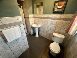 a bathroom with a toilet and a sink at Super Inn motel By Downtown Pomona in Pomona