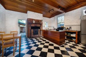 a kitchen with a fireplace and a checkered floor at Saint Francis in Fitzroy in Melbourne