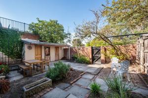 a patio with a table and chairs in a backyard at Saint Francis in Fitzroy in Melbourne