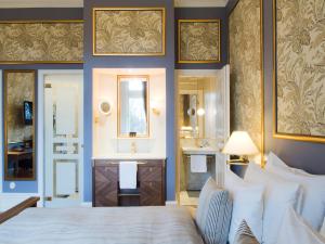 a hotel room with a large bed and a large mirror at Grand Hotel Lund in Lund