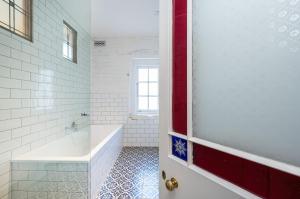 a bathroom with a tub and a sink and a door at Saint Francis in Fitzroy in Melbourne +29 photos