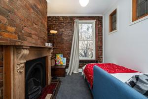 a bedroom with a brick wall and a bed and a fireplace at Saint Francis in Fitzroy in Melbourne