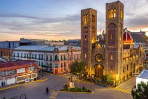 an old building with two towers in a city at Mina la Prieta 2 Apartment in Hidalgo del Parral