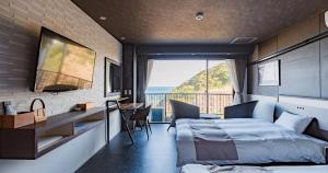 a bedroom with a bed and a view of the ocean at Hotel SEASONS NICHINAN in Nichinan