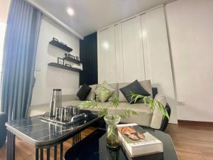 a living room with a couch and a table at SoSa Home in Ha Long