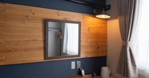 a bathroom with a mirror on a wooden wall at Hotel SEASONS NICHINAN in Nichinan +134 photos