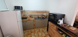 a small kitchen with a microwave and a refrigerator at 3 room apartment 50 m2 Appartement 3 pièces 50 m2 in Saint-Joseph
