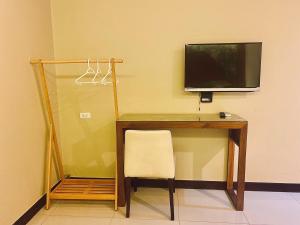 a desk with a television and a chair in a room at Le Ram Hotel No window in Bangkok