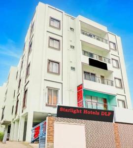 a tall white building with a sign in front of it at Hotel Starlight Chennai near DLF,L&T,Miot,Tradecenter,Ramachandra medical coll in Chennai