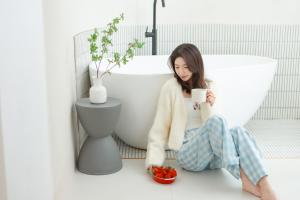 a woman sitting on the floor with a cup of coffee at EUPHORIA丨Quiet Garden Quiet Designer Garden Hotel丨Datang Never Sleeps City Big Wild Goose Pagoda Subway Station Branch丨Near the scenic area in Xi'an