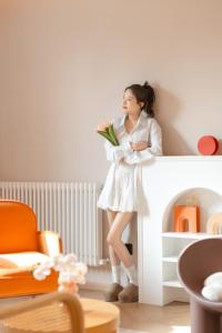a young girl in a white dress holding a flower at EUPHORIA丨Quiet Garden Quiet Designer Garden Hotel丨Datang Never Sleeps City Big Wild Goose Pagoda Subway Station Branch丨Near the scenic area in Xi'an