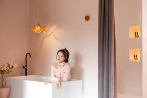 a little girl sitting on top of a white bath tub at EUPHORIA丨Quiet Garden Quiet Designer Garden Hotel丨Datang Never Sleeps City Big Wild Goose Pagoda Subway Station Branch丨Near the scenic area in Xi'an