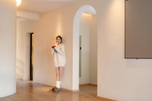 a woman in a white dress standing in a room at EUPHORIA丨Quiet Garden Quiet Designer Garden Hotel丨Datang Never Sleeps City Big Wild Goose Pagoda Subway Station Branch丨Near the scenic area in Xi'an