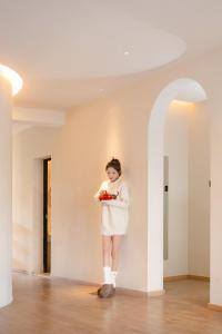 a woman standing in a room holding a plate of food at EUPHORIA丨Quiet Garden Quiet Designer Garden Hotel丨Datang Never Sleeps City Big Wild Goose Pagoda Subway Station Branch丨Near the scenic area in Xi'an