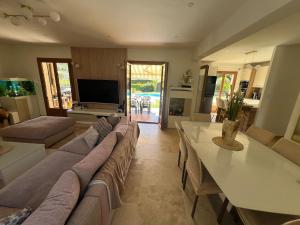 un ampio soggiorno con divano e tavolo di Charming Provençal Villa with pool and garden a Mougins