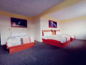 a room with two beds in a room at Hotel Azulejos in San Cristóbal de Las Casas +3 photos
