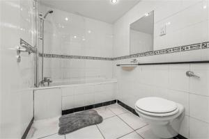 a bathroom with a toilet and a tub and a sink at Cheap modern room in Dublin
