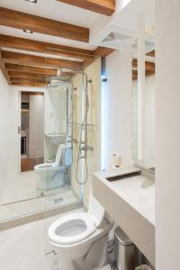 a bathroom with a toilet and a glass shower at Cozy Cabin Style 48 sqm 500MBPS in Mandaue City