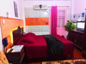 ein Schlafzimmer mit einem roten Bett und einem Fenster in der Unterkunft Fayrouzat Near the sea with garden Vew in Alexandria