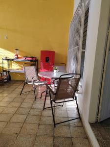 una mesa y sillas en una habitación con una pared amarilla en Casa Kika, en Mazatlán