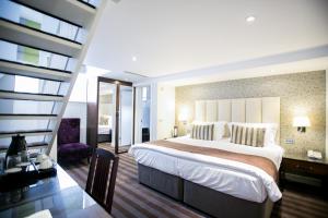 a hotel room with a large bed and a large window at The Pillar Hotel in London
