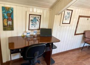 an office with a wooden desk with a computer on it at A Cabana in Campos do Jordão