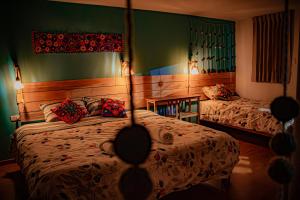a bedroom with two beds and a table at "CASITA AZUL"- Apartamento con bonita vista Volcan in Chivay