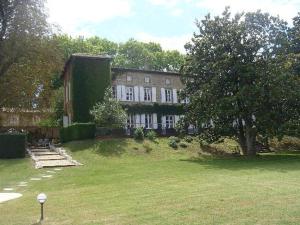 a large brick house with a tree in the yard at Le Domaine des Buis in Albon