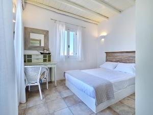 a bedroom with a bed and a desk with a mirror at amazing sea view luxury villa for 6 guests in Ambelas