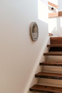 a round mirror on the wall next to stairs at Central Goolwa- Coastal Family & Friend Retreat in Goolwa +39 photos